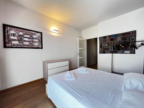 a bedroom with a white bed and two pictures on the wall at Mole Antonelliana - Box Auto Gratuito by RD Domus in Turin