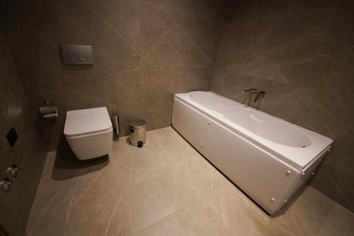 a bathroom with a white sink and a toilet at The Central View Boutique Hotel in Vlorë