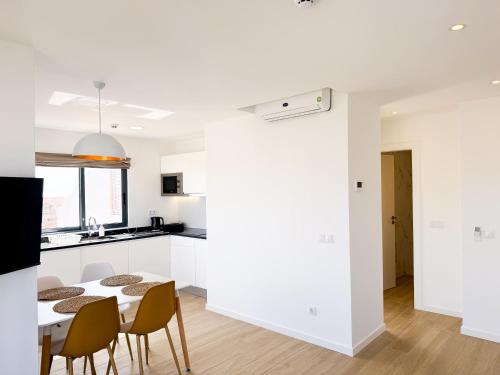 a kitchen and dining room with a table and chairs at BIA D'Olaf Apartments in Santa Maria