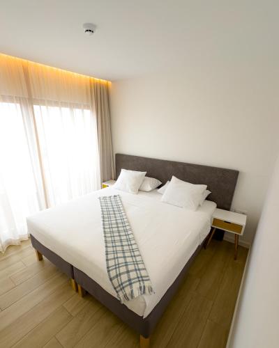 a bedroom with a large bed with white sheets and pillows at BIA D'Olaf Apartments in Santa Maria