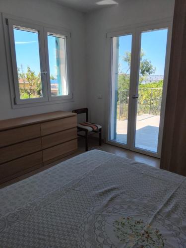 a bedroom with a bed and a dresser and windows at Zefiro Azzurro in Bordighera