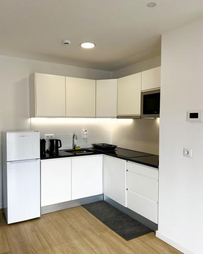 a white kitchen with white cabinets and appliances at BIA D'Olaf Apartments in Santa Maria