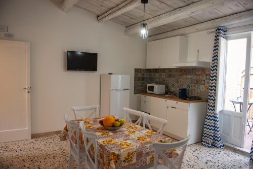 a kitchen with a table with a bowl of fruit on it at Holiday House Annunziata in Termini Imerese