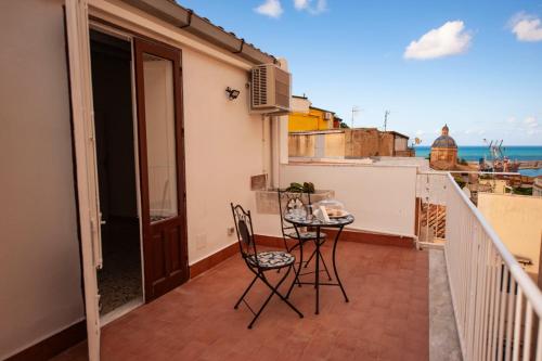 a balcony with two chairs and a table on it at Holiday House Annunziata in Termini Imerese