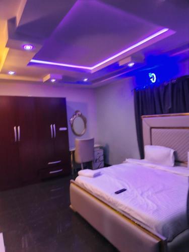 ein Schlafzimmer mit einem Bett und einer lila Decke in der Unterkunft Vitaluxury apartment 2 in Akowonjo