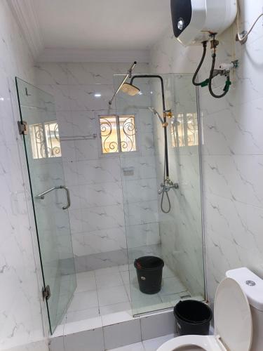ein Badezimmer mit Glasdusche und Toilette in der Unterkunft Vitaluxury apartment 2 in Akowonjo
