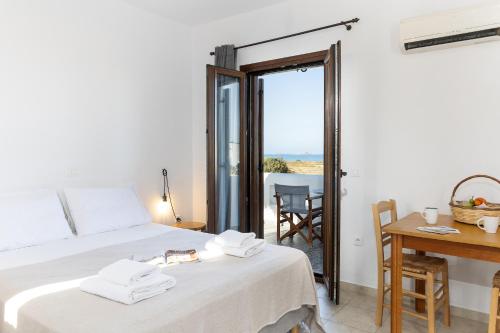 a bedroom with a bed and a table and a view of the ocean at Studio Tolakis in Plaka
