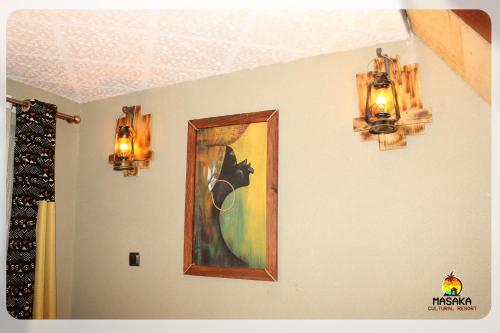 a painting of a horse on a wall with two lights at Masaka Cultural Resort in Masaka