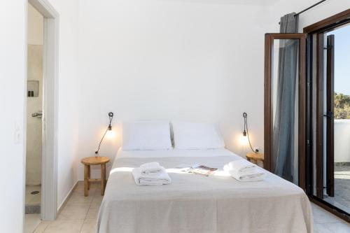 a bedroom with a white bed with towels on it at Studio Tolakis in Plaka