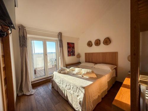 a bedroom with a bed and a large window at Tenuta Rurale Luxury&Nature in Gravina in Puglia