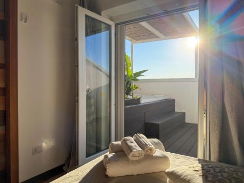 a room with a balcony with towels on a bed at Tenuta Rurale Luxury&Nature in Gravina in Puglia