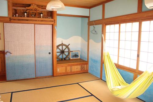 a room with a hammock in the corner of a room at Katsuo Guest House in Kochi
