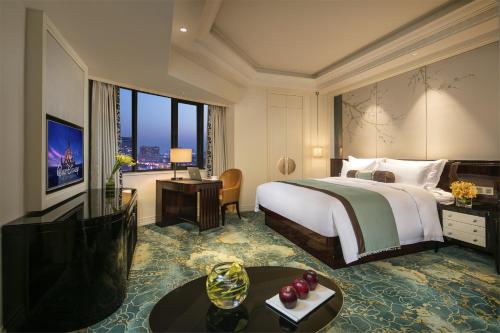 a hotel room with a bed and a large window at The Pury Hotel in Yiwu
