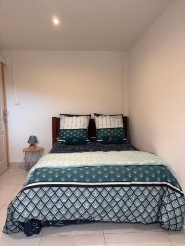 a bedroom with a large bed with green pillows at Maison Arum in La Plaine des Palmistes