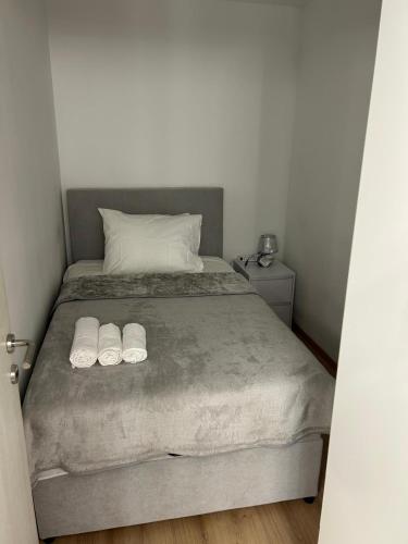 a bedroom with a bed with two white slippers at Apartman GUŠI in Knin