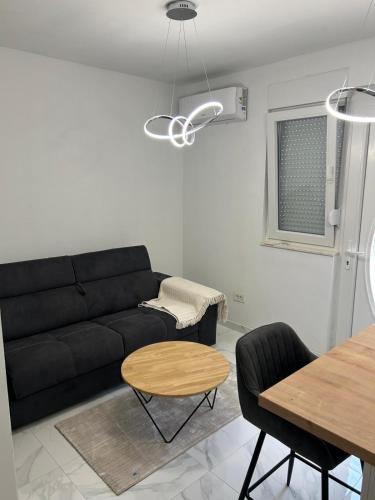 a living room with a black couch and a table at Apartman GUŠI in Knin