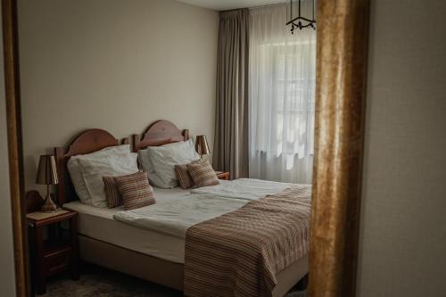 a bedroom with a bed and a window at Hotel Aubrecht Country Spa Resort in Przechlewo