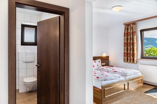 a small bedroom with a bed and a toilet at Pension Heidelberg in Hopfgarten im Brixental