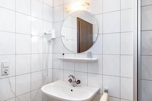 a white bathroom with a sink and a mirror at Pension Heidelberg in Hopfgarten im Brixental