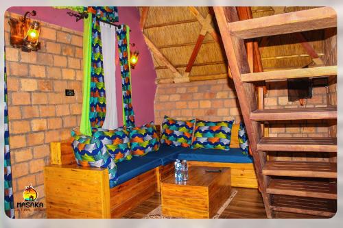 a living room with a blue couch and a table at Masaka Cultural Resort in Masaka