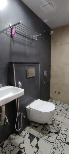 a bathroom with a white toilet and a sink at PubliQ Luxury Stays KPHB in Hyderabad