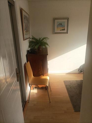 a room with a chair and a desk with a plant at Double room, Belhaven, Dunbar in Dunbar