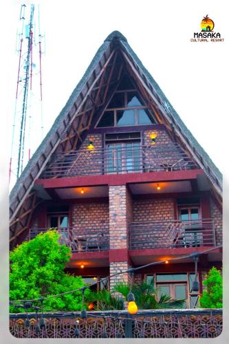 a red building with a gambrel roof at Masaka Cultural Resort in Masaka