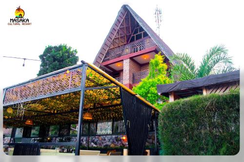 a house with a large window and a building at Masaka Cultural Resort in Masaka