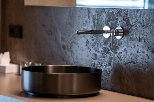 a copper sink on a counter with a faucet at Dolomites Nature Hotel Vigilerhof in Siusi