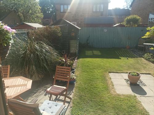 a backyard with two chairs and a lawn with a fence at Double room, Belhaven, Dunbar in Dunbar