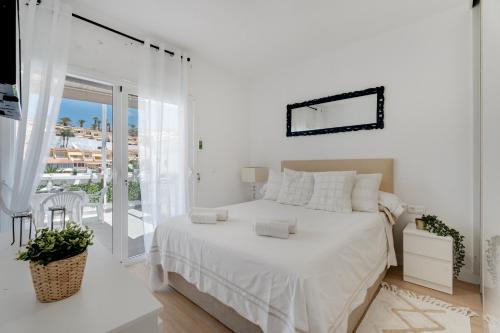 Un dormitorio blanco con una cama y un balcón. en Sun Garden, en Adeje