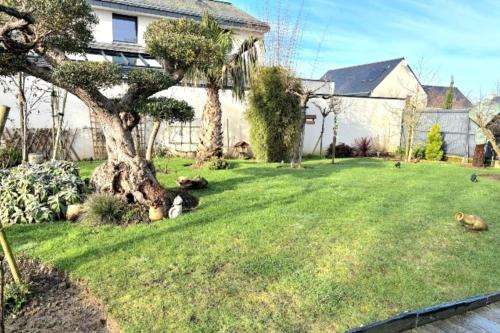 une cour avec un arbre et une maison dans l'établissement Spacious house with garden near the beach, à Saint-Malo