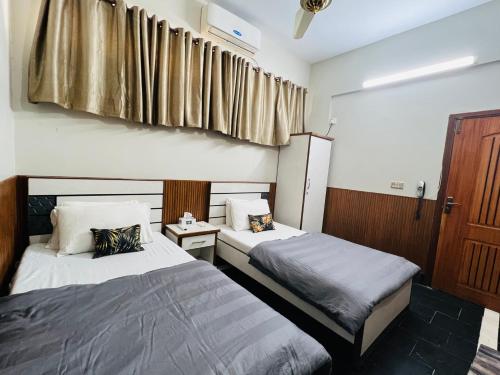 a bedroom with two beds and a window at Karachi Inn in Karachi