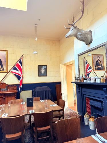 a dining room with a table and a fireplace at Criterion Boutique Hotel in Oamaru