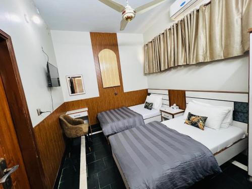 a small room with two beds and a tv at Karachi Inn in Karachi
