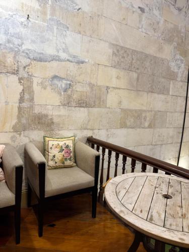 a balcony with two chairs and a coffee table at Criterion Boutique Hotel in Oamaru