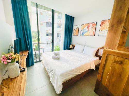 a bedroom with a bed with a teddy bear on it at 407MSNK Maison Luxe Studio w Balcony & Kitchen in Can Tho
