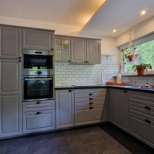 a kitchen with white cabinets and an oven at Ferienhaus an der Brandenburgischen Seenplatte in Lindow