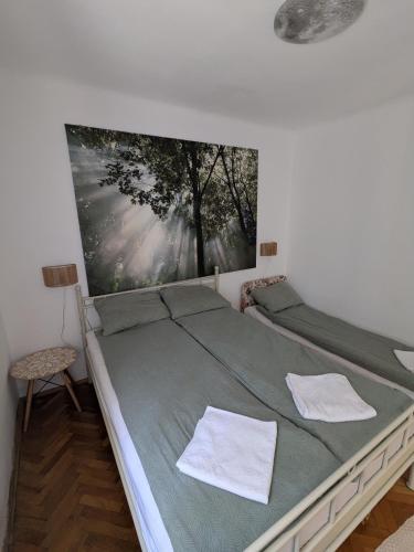 a bedroom with a bed with a painting on the wall at Urban Oasis in Târgu-Mureş