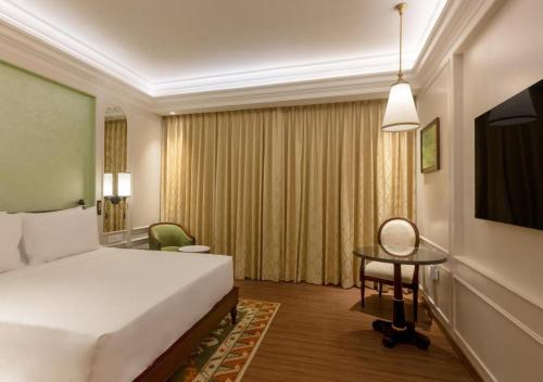 a hotel room with a bed and a desk and a television at Namah Nainital, a member of Radisson Individuals Retreats in Nainital