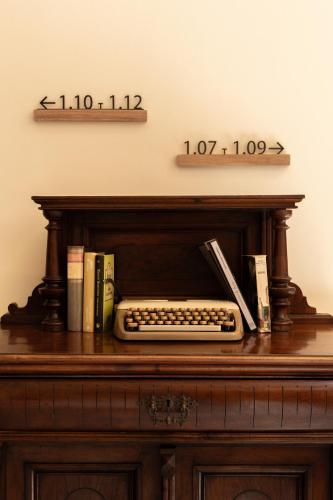 a desk with a keyboard and a clock on the wall at Hotel Palacio de Hemingway in Ronda