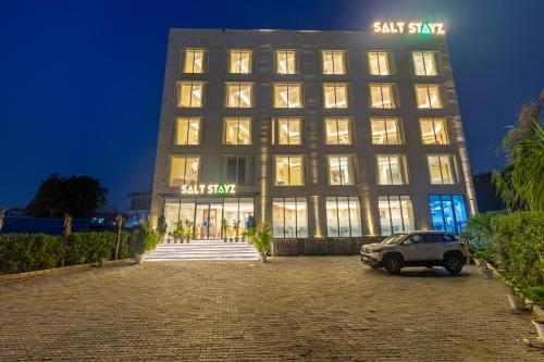 a building with a car parked in front of it at Saltstayz Premier - Manesar & Sector 86 in Gurgaon