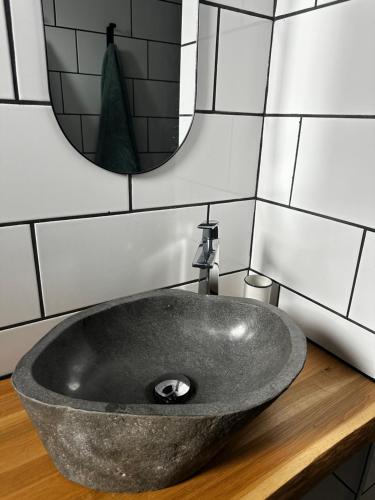 a stone sink in a bathroom with a mirror at La Suite élégante in Saint Lo
