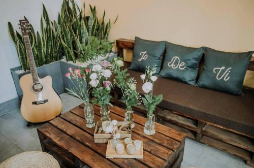 a living room with a couch and a table with flowers at Pamela Homestay Cao Bằng in Cao Bằng