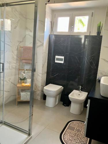 a bathroom with a toilet and a glass shower at Casa Ulivo in San Sperate