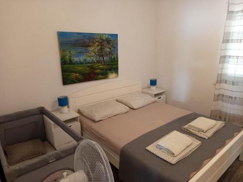 a small bedroom with a bed and a chair at Sea View Apartment Sunrise Poljica & Blue Lagoon Rent A Boat in Poljica