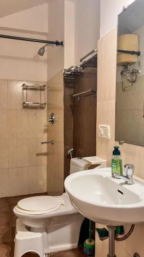 a bathroom with a white toilet and a sink at GoArize by Rootsvilla Vagator in Anjuna