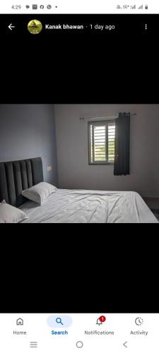 a picture of a bedroom with a bed and a window at Kanak Bhawan in Vrindāvan