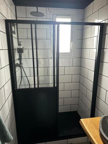 a shower with a glass door in a bathroom at La Suite élégante in Saint Lo