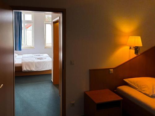 a room with a bedroom with a bed and a window at Stadthotel Kolpinghaus - Vier Ecken in Werne an der Lippe
